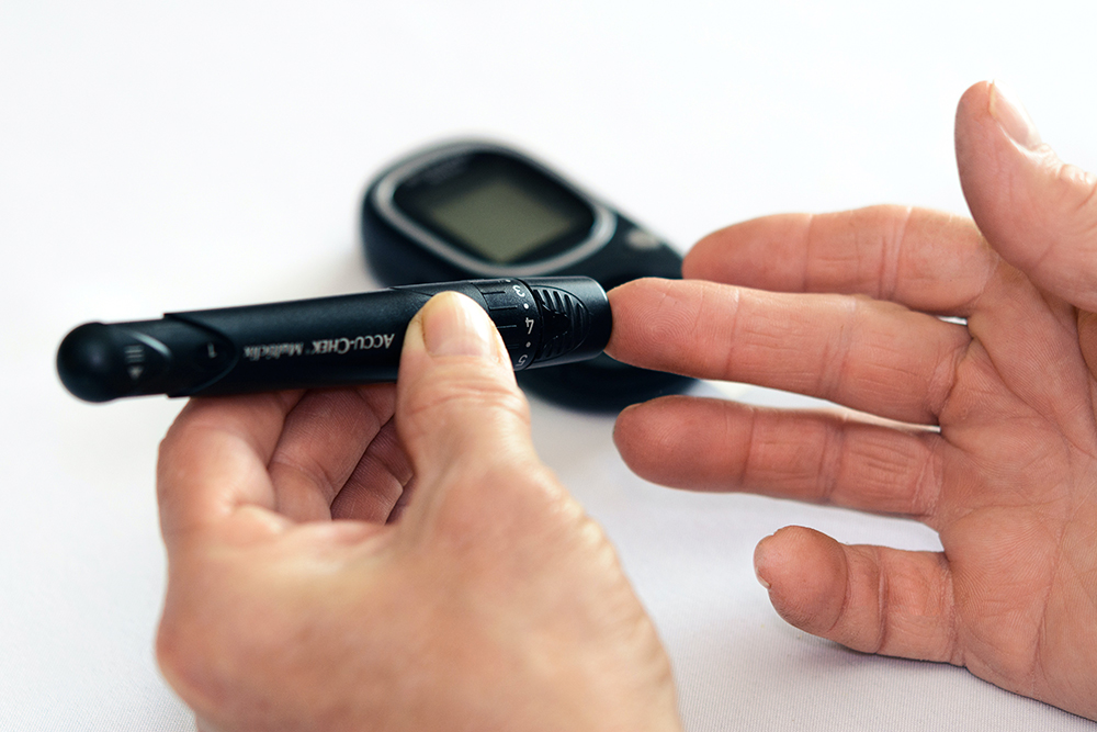 person taking a sample of diabetes from his or her finger