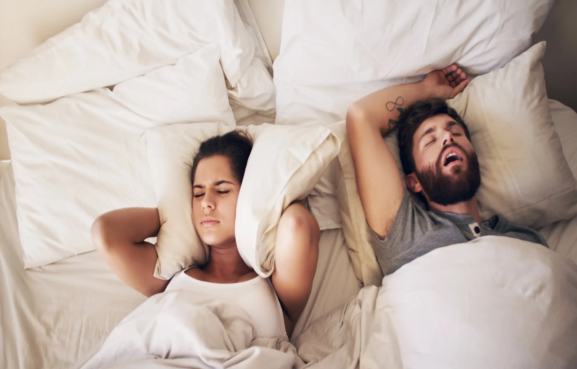 woman-covering-her-ears-because-her-husband-snores