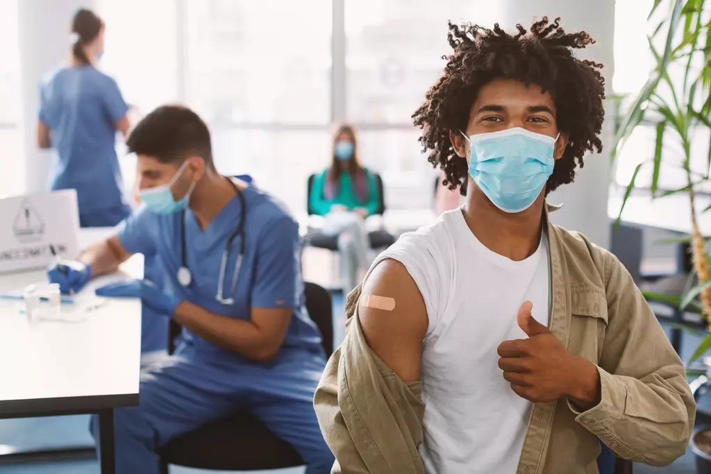 Happy black guy in mask showing thumbs up after